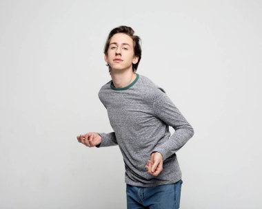 Modaya uygun genç adam müzikle dans ediyor.