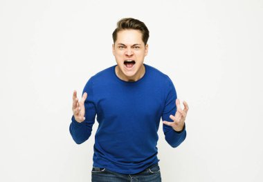 Yakışıklı adam izole edilmiş arka planda bağırıyor ve bir şey duyuruyor.