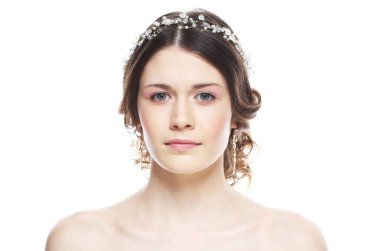 Saçlarında muhteşem diyademi olan genç gelin, pembe arka planı kapatıyor.