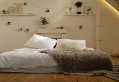 Yatak odasında yatak, beyaz yastıklar ve rahat çarşaflar.