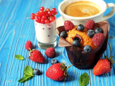 Sabah kahvaltısı. Böğürtlenli kek, bir fincan kahve ve üzümlü yoğurt.