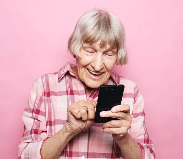 老白发苍苍的老太太看着手机屏幕的画像 — 图库照片