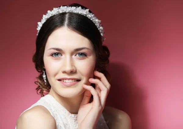 Beautiful bride with fashion wedding hairstyle - on pink background. — Stock Photo, Image