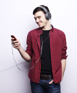 Beyaz arka planda müziğe izin veren yakışıklı adam