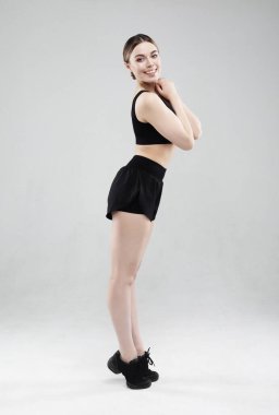 Gri arka planda duran güzel fitness kadını