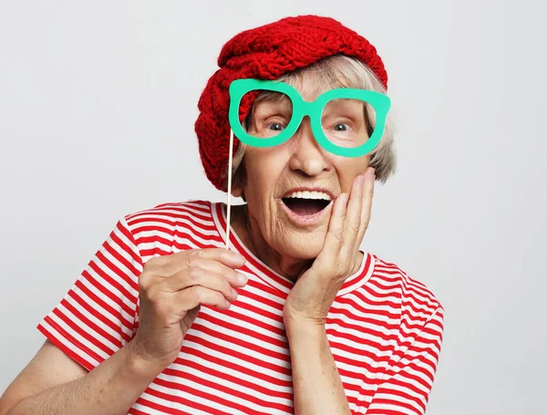 Lifestyle, άνθρωποι και κόμμα έννοια: αστεία γιαγιά φορώντας κόκκινα ρούχα έτοιμα για το κόμμα — Φωτογραφία Αρχείου