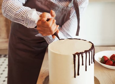 Pastayı yakın plan kadın süslüyor.