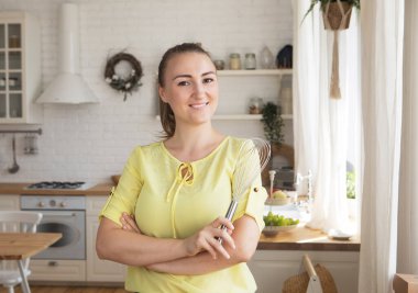 Güzel genç kadın şef modern kithcen 'i çırpıyor.