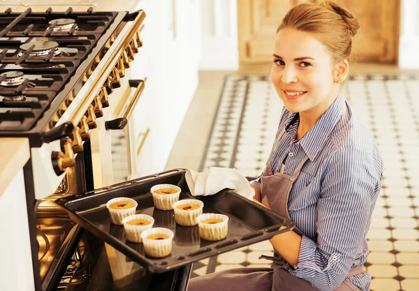 Young woman making muffins in white kitchen. — Stock Photo, Image