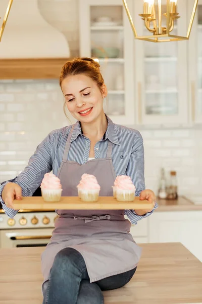 Young baker woman holding cupcakes. — Stock Photo, Image