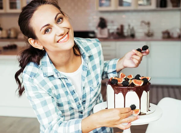A cukrász bogyókkal és fügével díszíti a tortát.. — Stock Fotó