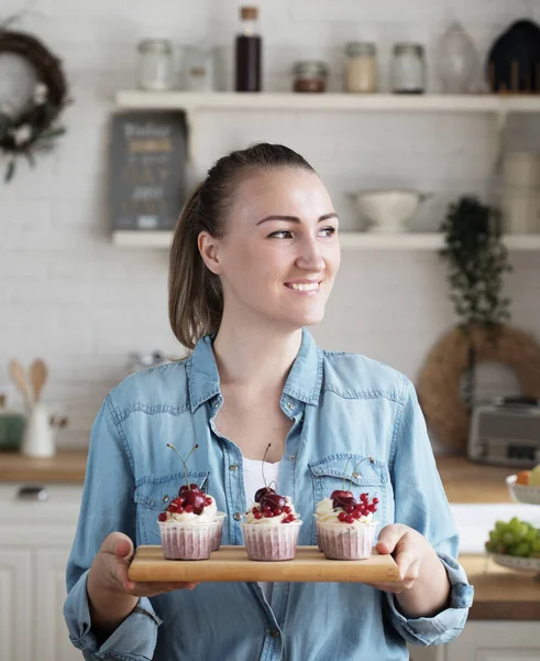 Young baker woman holding cupcakes. — Stock Photo, Image