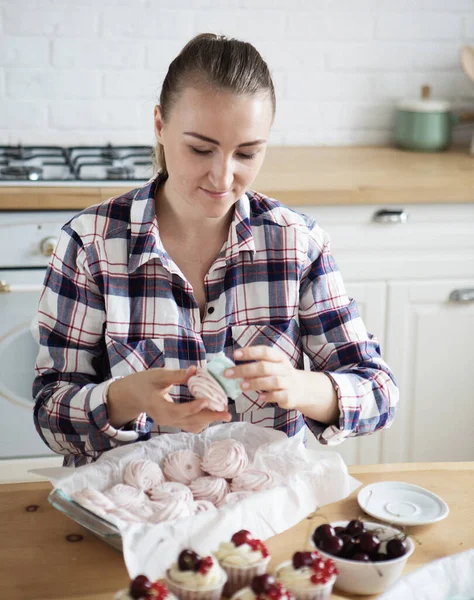 Beautiful woman pastry chef makes sweet cakes in kitchen — Stock Photo, Image