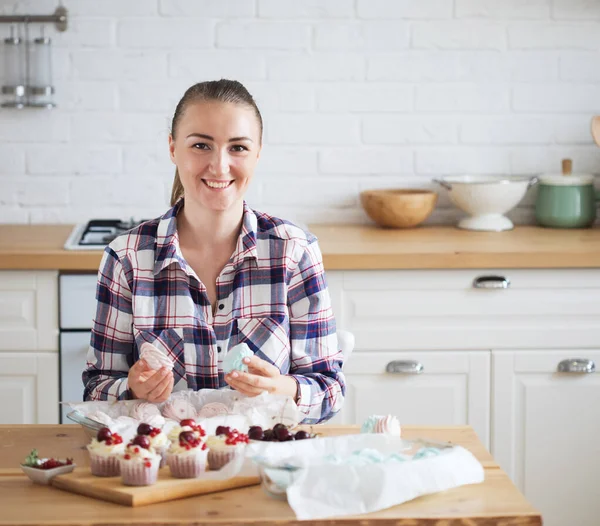 Beautiful woman pastry chef makes sweet cakes in kitchen — Stock Photo, Image
