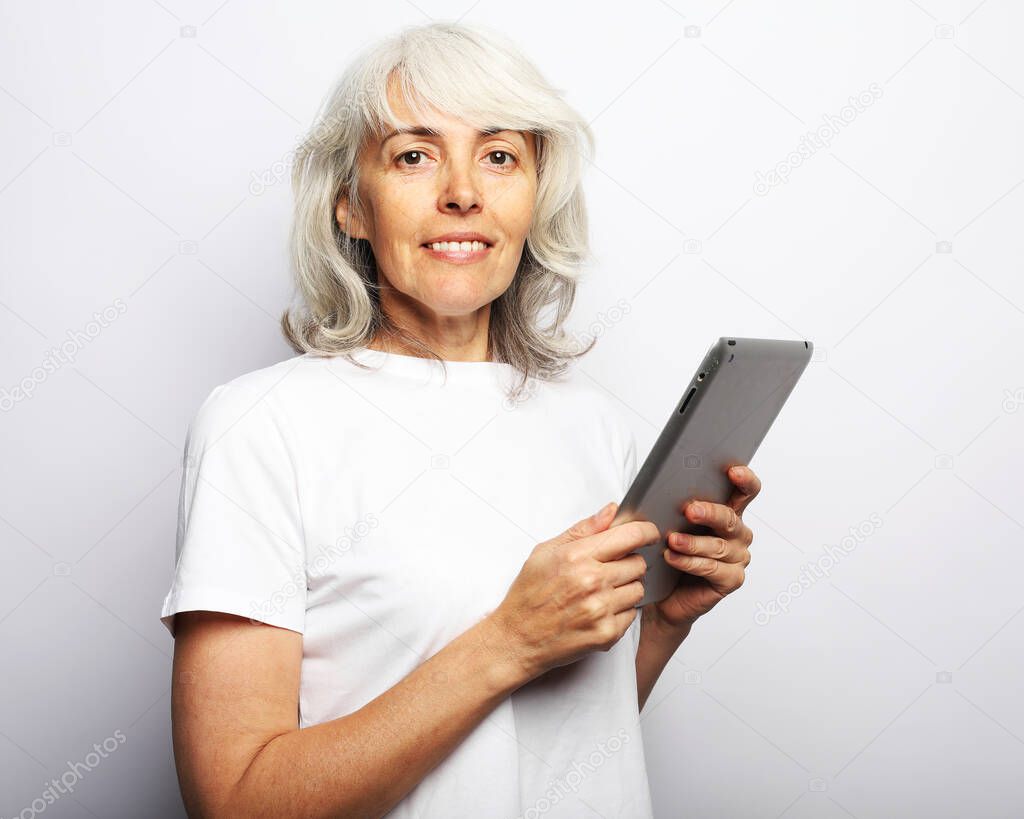 mature woman using a tablet, communicates with children and grandchildren