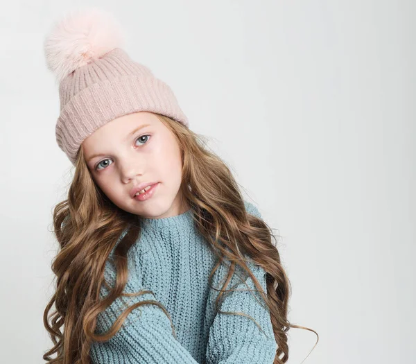 Felice bambina indossa maglione blu e cappello invernale su sfondo bianco — Foto Stock