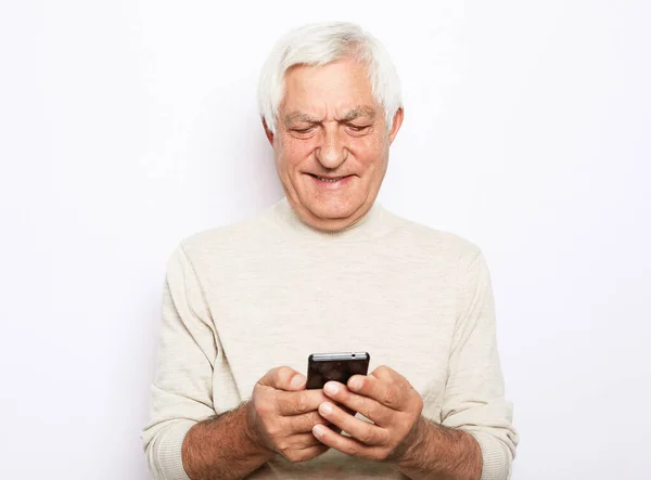 Gammal aktiv man med mobiltelefon isolerad på vit bakgrund — Stockfoto