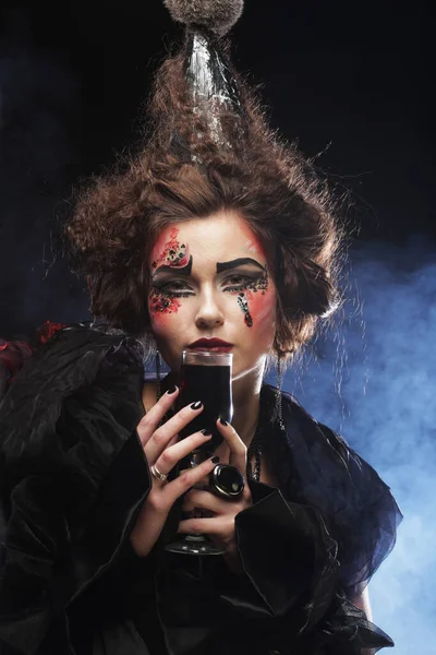 Young woman with gothic make-up and crazy hair-style. Creative fashion masquerade.