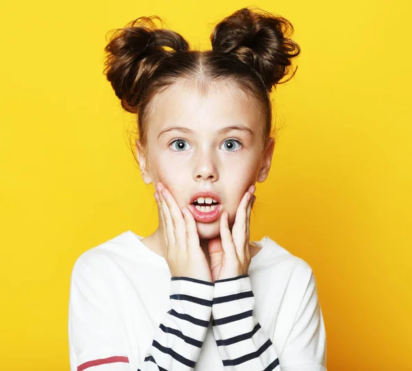 Ritratto di allegra bambina sorpresa su sfondo giallo — Foto Stock