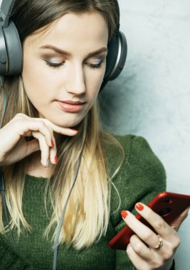İnsanlar ve teknoloji kavramı - kulaklıklı mutlu genç kadın akıllı telefondan müzik dinliyor.