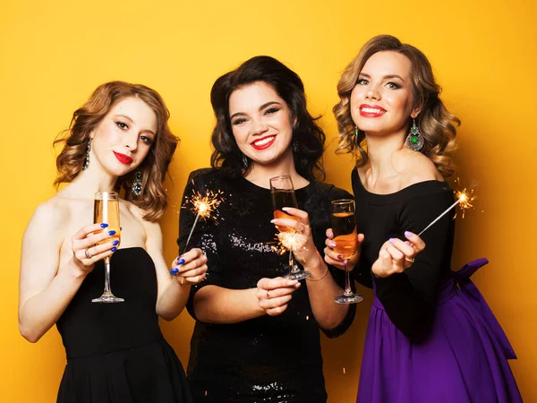 Sarı Arka Planda Şampanya Bardakları Maytapları Olan Güzel Genç Kadının — Stok fotoğraf