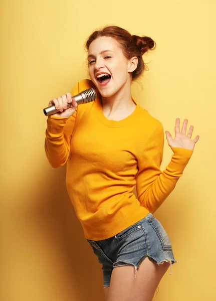 Весела Молода Руда Жінка Одягнена Шорти Жовтий Светр Тримає Мікрофон — стокове фото