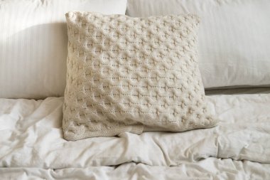 Yatak odasında yatak, beyaz yastıklar ve rahat çarşaflar.