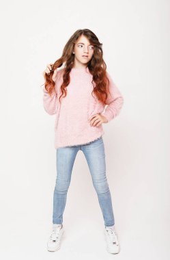 Beyaz arka planda poz veren tatlı kıvırcık kız. Yaşam tarzı ve moda konsepti.