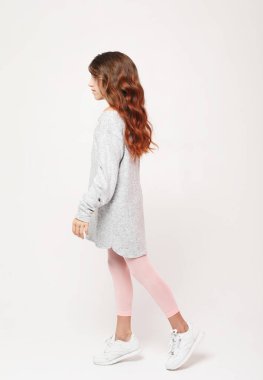 Beyaz arka planda poz veren tatlı kıvırcık kız. Yaşam tarzı ve moda konsepti.