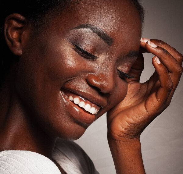 Lifestyle and people concept: Close up portrait of beautiful young african woman laughing, studio shot