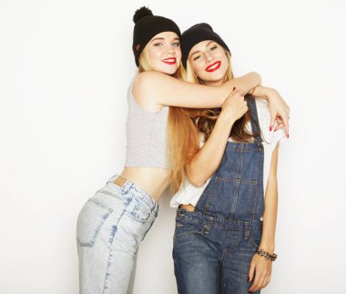 Yaşam tarzı, arkadaşlık ve insan konsepti: iki genç kız arkadaş bir arada duruyor ve eğleniyorlar. Kameraya bakıyorum..