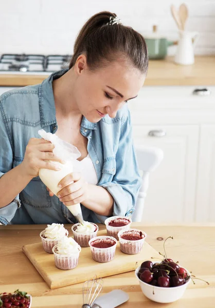 Lifestyle People Concept Young Woman Decorates Muffins White Cream Her — Stock Photo, Image