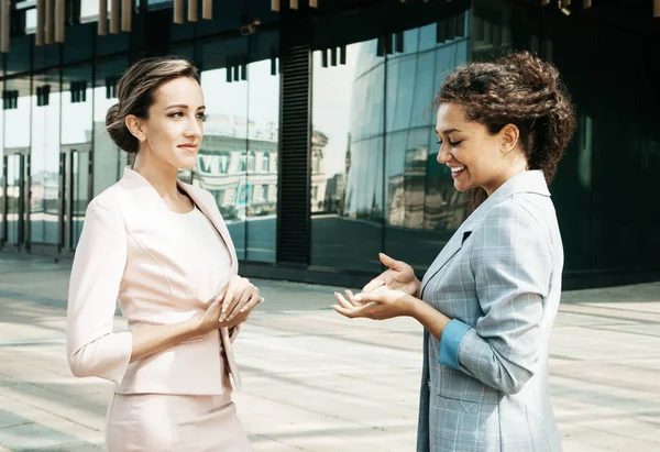 Concepto de negocio, gente y estilo de vida: Dos empresarias diversas. Emocionado afro femenino compartir ideas o plan de negocio de inicio con la mujer rubia. Conversación informal, concepto de descanso laboral —  Fotos de Stock