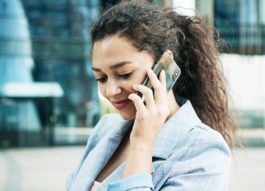 İş, iletişim, teknoloji ve insanlar konsepti - genç gülümseyen Afrikalı Amerikalı iş kadını akıllı telefondan arıyor