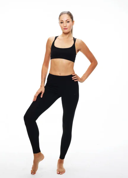 Porträtt av vacker ung kvinna bär sportkläder träna i studio. Passar sportig tjej som gör yoga. Full längd. — Stockfoto