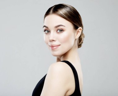 Sağlıklı, taze bir yüz, güzel genç bir kadın. Gri arkaplanı temiz ciltli, yakın bir yüz.