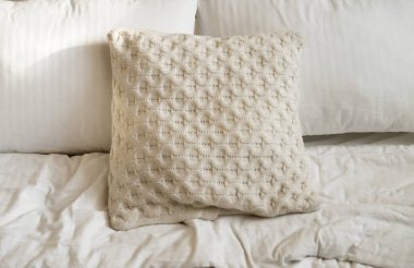 Yatak odasında yatak, beyaz yastıklar ve rahat çarşaflar.