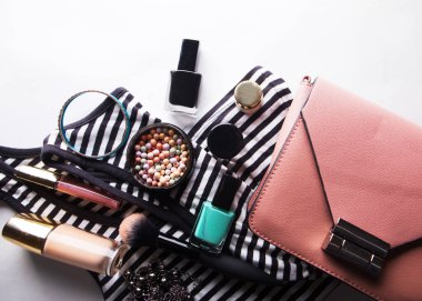 Güzellik ve moda kavramı: Pembe deri kadın çantasının, kozmetik ürünlerinin, aksesuarların ve beyaz arka planda fotokopi alanı olan akıllı telefonun düz uzantısı