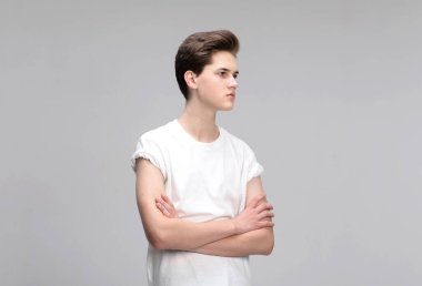 Gri arka planda izole edilmiş yüksek model erkek portresi. Yakından bakınca yakışıklı biri. Şık saç kesimi, saç şekli..