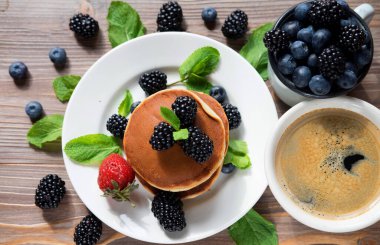 Yaban mersinli waffle ve ahududu tabakta. Ahşap arka planda kahve ve böğürtlen. Üst görünüm.