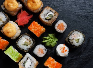 Japon suşi yemeği. Maki ve rulo ton balığı, somon, karides, yengeç ve avokado. Çeşit çeşit suşinin en üst görüntüsü. Gökkuşağı suşi rulosu, uramaki, hosomaki ve nigiri.