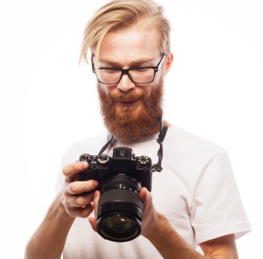 Beyaz arkaplanda dijital kamerayla fotoğraf çeken yakışıklı fotoğrafçı