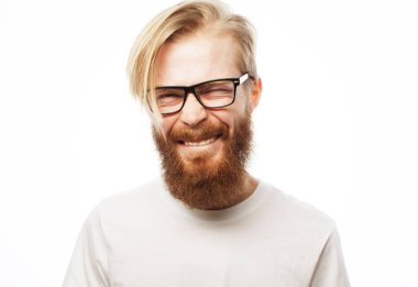 Beyaz arka planda beyaz tişörtlü ve gözlüklü yakışıklı bir adamın portresi.