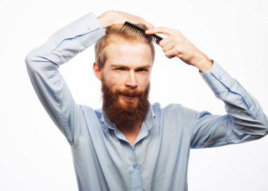 Yakışıklı, gülümseyen genç adam beyaz arka plan üzerinde modern saç stili yapıyor.