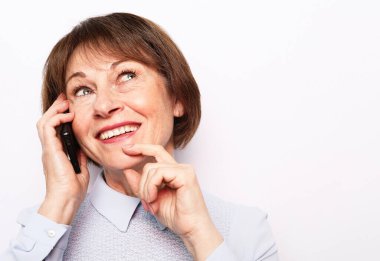 Teknoloji ve insanlar konsepti - beyaz arka planda arkadaşlarıyla telefon görüşmesi yapan mutlu son sınıf öğrencisi kadın