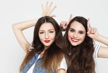 Boynuzlarını boynuzlarıyla gösteren iki sevimli kadının portresi.