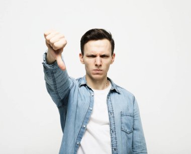 Genç, yakışıklı, sıradan kot gömlek giyen mutsuz ve sinirli görünen reddedilmiş ve olumsuz davranışlı bir genç..