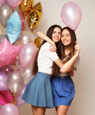 Yaşam tarzı ve insan konsepti: renkli balonları olan iki kız arkadaş - genç ve mutlu.