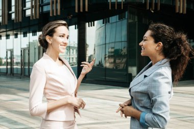 İki farklı iş kadını. Heyecanlı afro kadın fikirleri paylaşıyor ya da sarışın kadınla iş planı yapıyor..