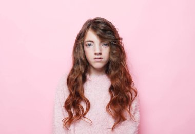 Onun güzel, sevimli, sevimli, sevimli, neşeli, dalgalı saçlı, izole, pembe arkaplanlı portresi. Yaşam tarzı kavramı.